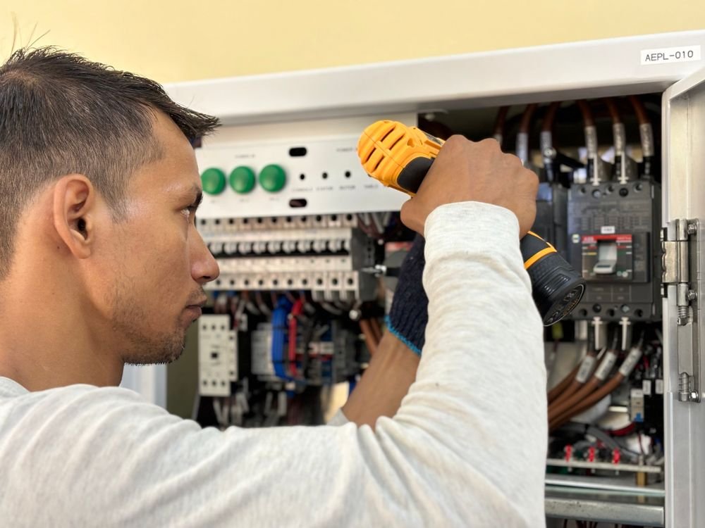 Eletricista profissional realizando manutenção em painel elétrico residencial